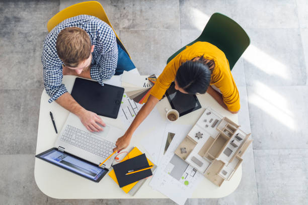 Overhead view of two architects working on a project in the office